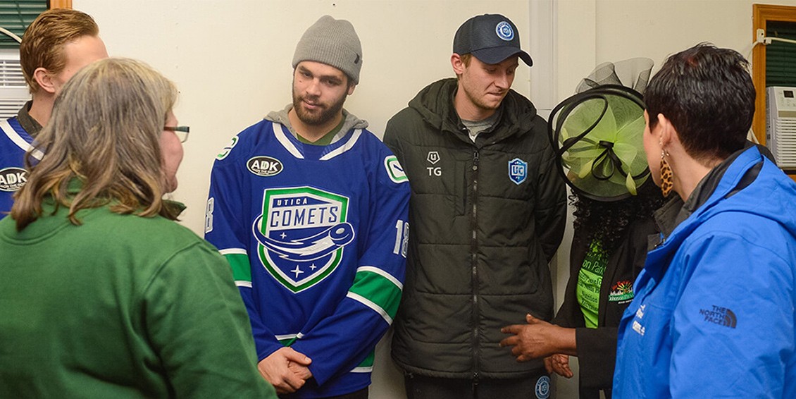 Members of the Utica Football Club, The Utica Comets, and Wolfspeed talk together while at the Utica Rescue Mission.