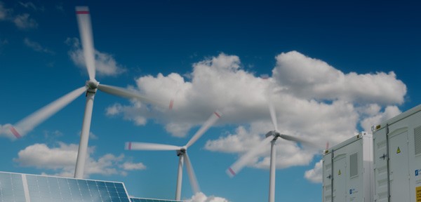 Solar panels and wind turbines in a field generating renewable energy, representing Wolfspeed's commitment to clean energy.