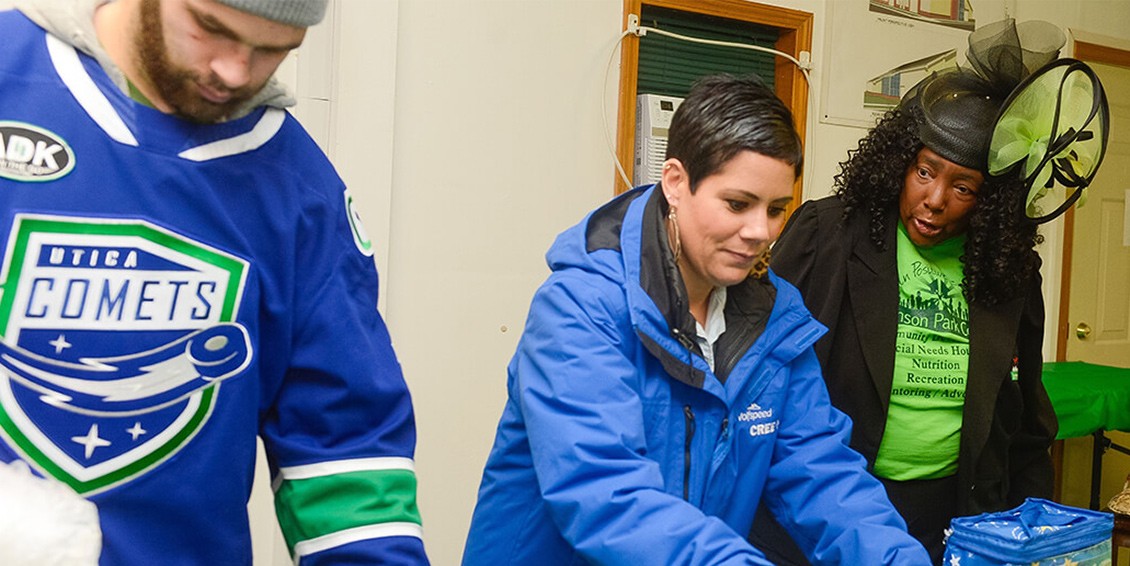 A Utica Comets team member, and a Wolfspeed team member, helps to distribute house goods to the Utica Rescue Mission