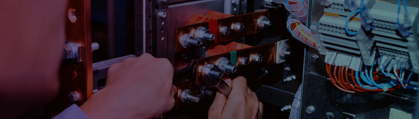 An electrician works on low voltage cabinet representing how Wolfspeed’s MOSFETs and diodes pack more backup power into a single enclosure.