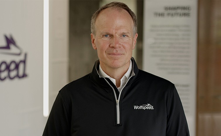 CEO Robert Feurle standing beside the Wolfspeed logo sign.