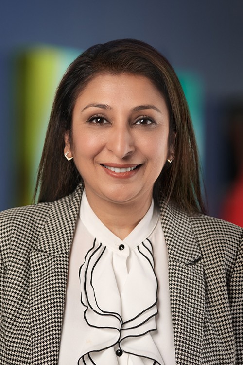 A professional headshot of Priya Almelkar, the Chief Information Officer &amp; SVP