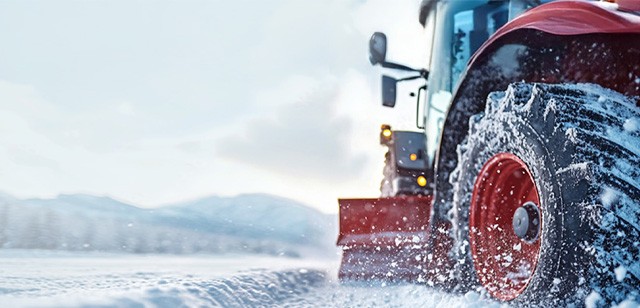 Close-up photo of a red tractor in a snow-covered field. Used to symbolize how Wolfspeed's portfolio is strong and durable.